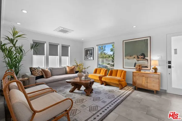 a living room with furniture fireplace and a large window