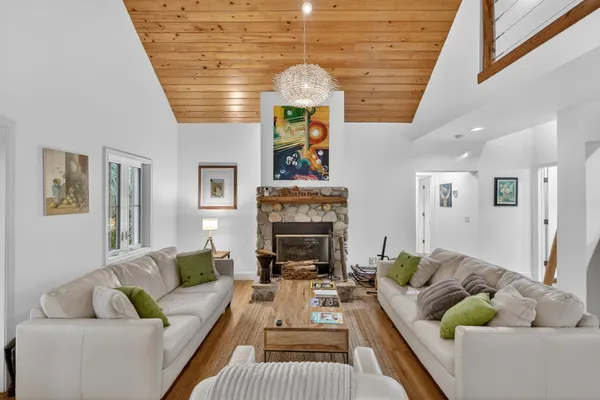 a living room with furniture a fireplace and a chandelier