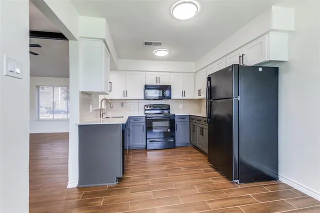 a kitchen with granite countertop a refrigerator and a stove top oven