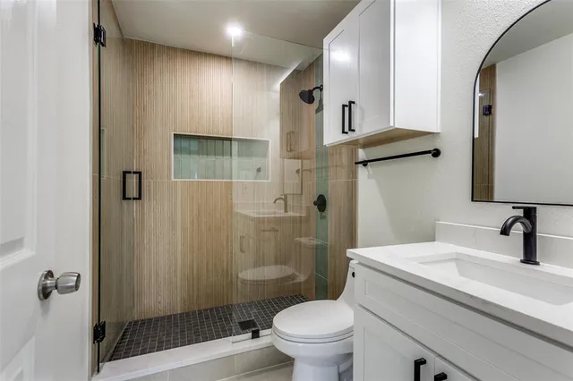 a bathroom with a sink a toilet and shower