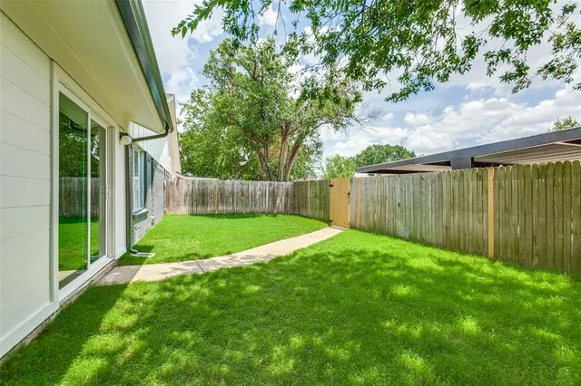 a view of a backyard with table and chairs and wooden fence