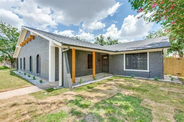 a view of a house with a yard and potted plants
