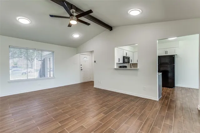 a view of a livingroom with wooden floor and a ceiling fan