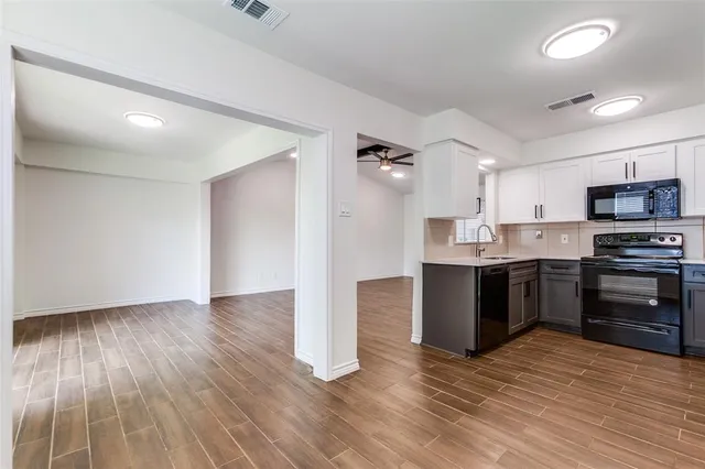 a kitchen with wooden floors and appliances