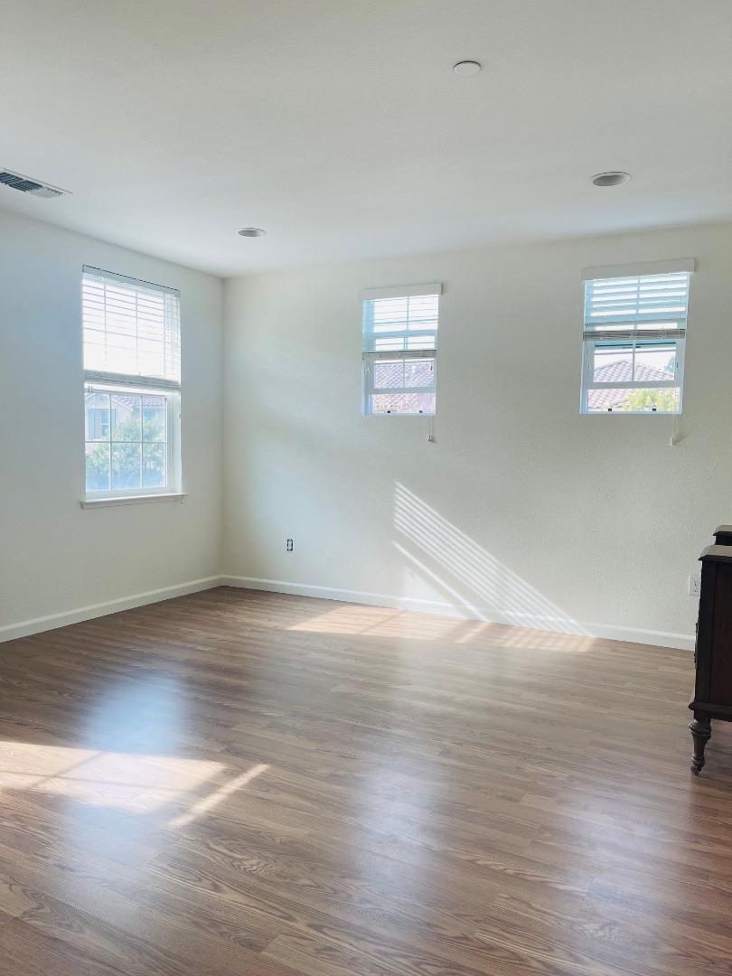 74 Caspian Way Gilroy, CA 95020 - Photo 11 of 18 a view of an empty room with wooden floor and a window