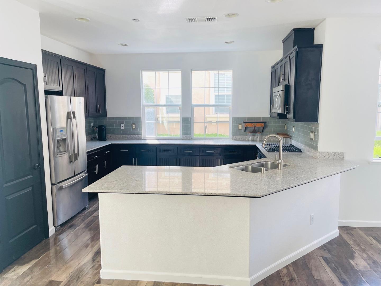 74 Caspian Way Gilroy, CA 95020 - Photo 3 of 18 a kitchen with granite countertop a sink and a refrigerator