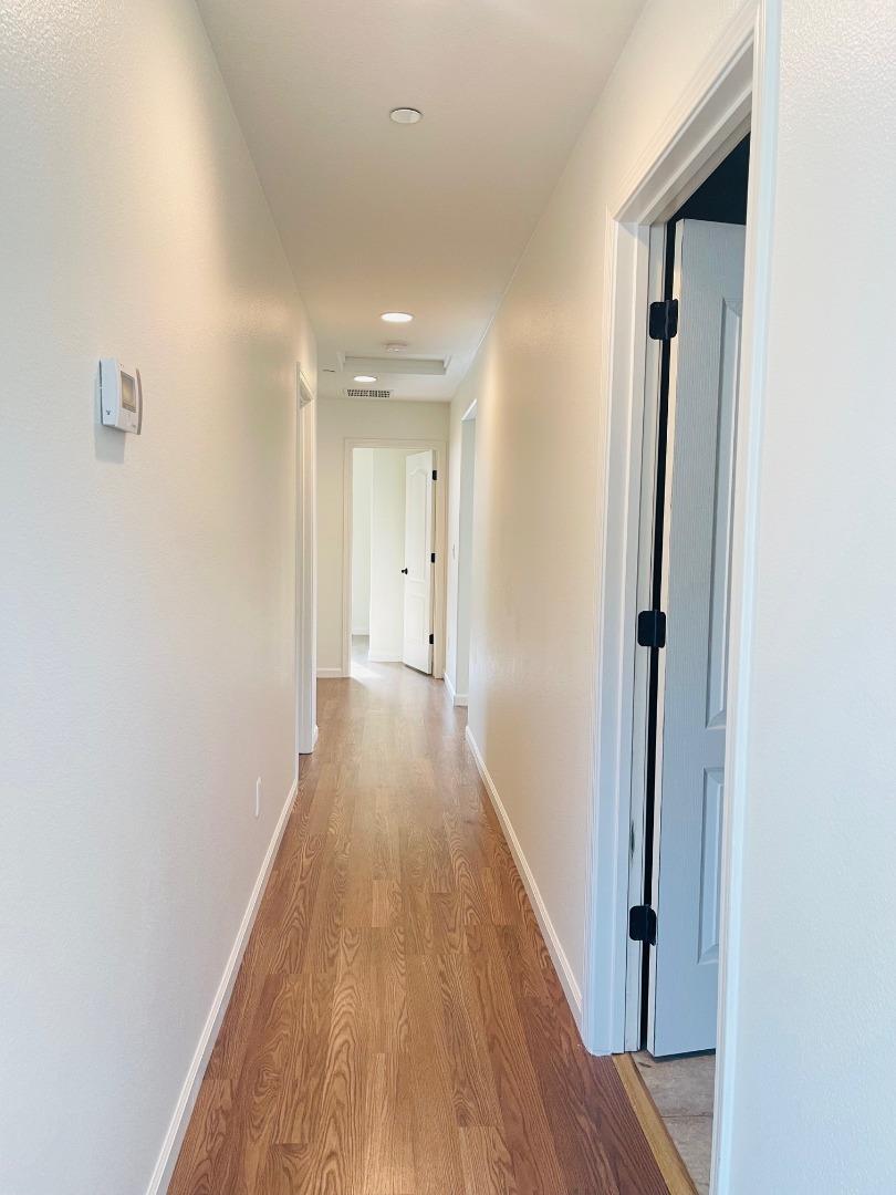 74 Caspian Way Gilroy, CA 95020 - Photo 9 of 18 a view of a hallway with wooden floor and a bathroom
