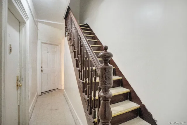 a view of staircase with wooden floor and white walls