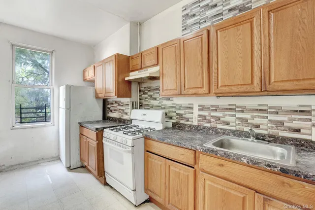 a kitchen with stainless steel appliances granite countertop a sink stove and cabinets