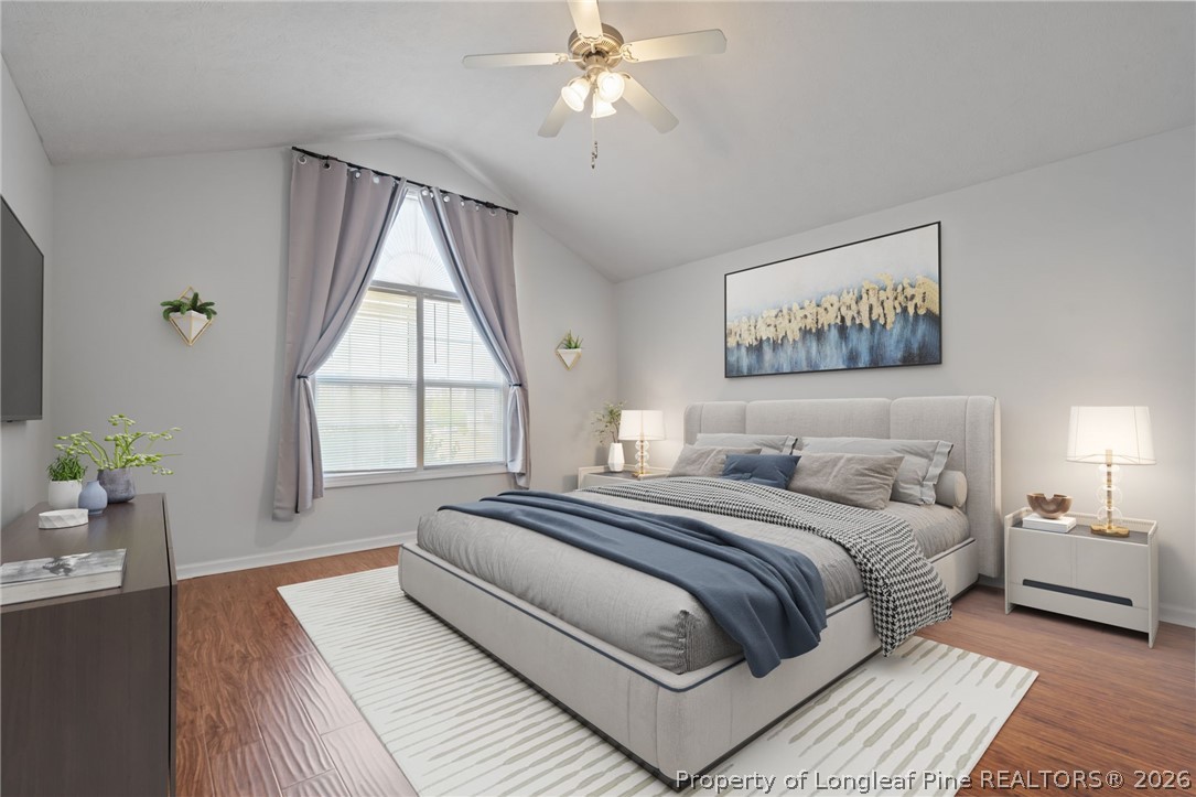115 Shelby Street Spring Lake, NC 28390 - Photo 20 of 40 a bedroom with a large bed and a chandelier