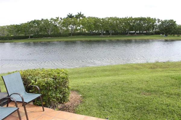 a view of a lake with a yard and trees