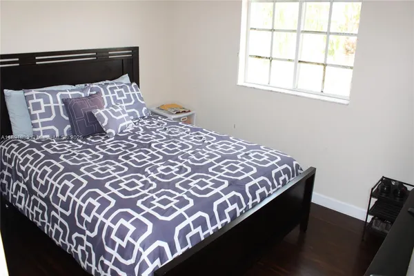 a large bed sitting in a bedroom next to a window