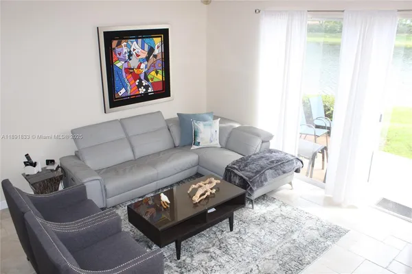 a living room with furniture and a painting on the wall