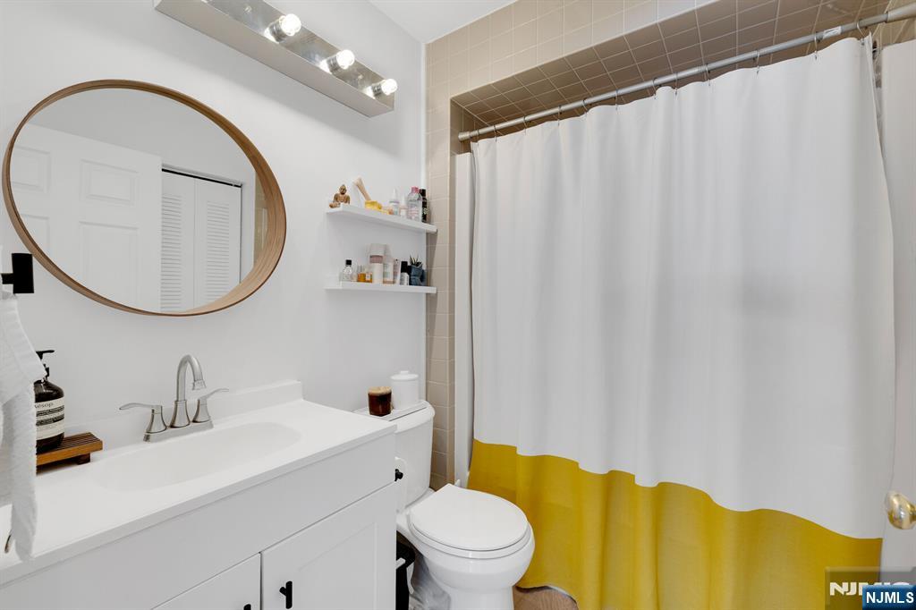 199 Union Avenue, Unit 2F Rutherford, NJ 07070 - Photo 11 of 25 a bathroom with a sink a toilet and a mirror