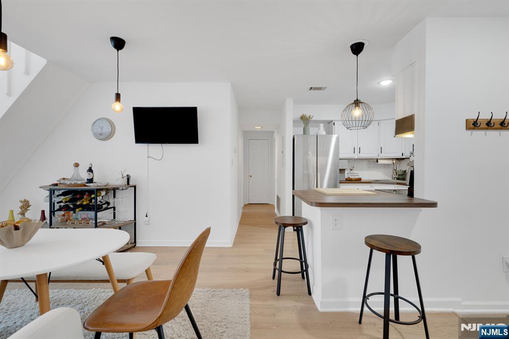 199 Union Avenue, Unit 2F Rutherford, NJ 07070 - Photo 10 of 25 a kitchen with stainless steel appliances kitchen island granite countertop a dining table chairs and a refrigerator