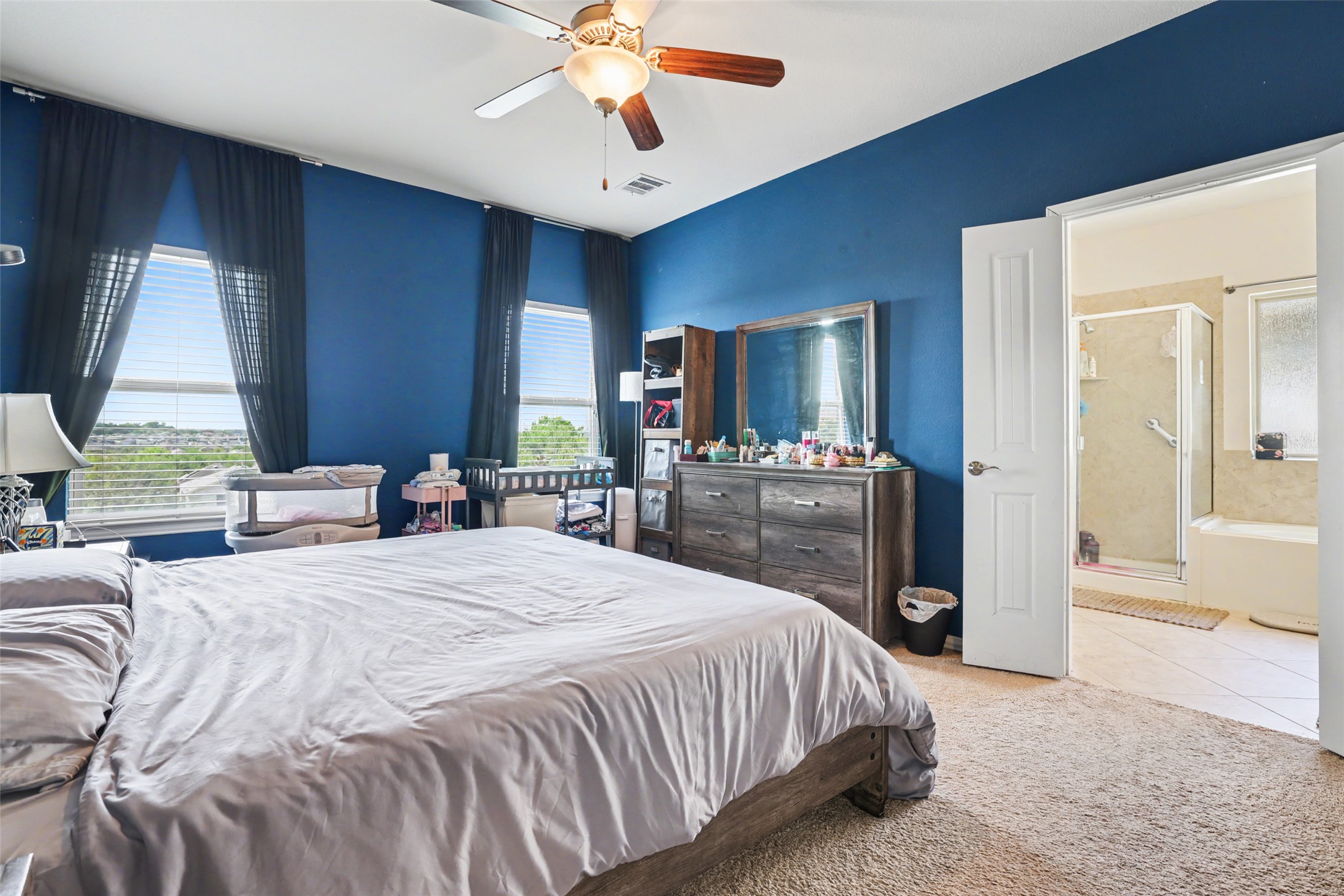 5845 Kleberg Trail Austin, TX 78747 - Photo 12 of 30 a bedroom with a bed dresser and a flat tv screen