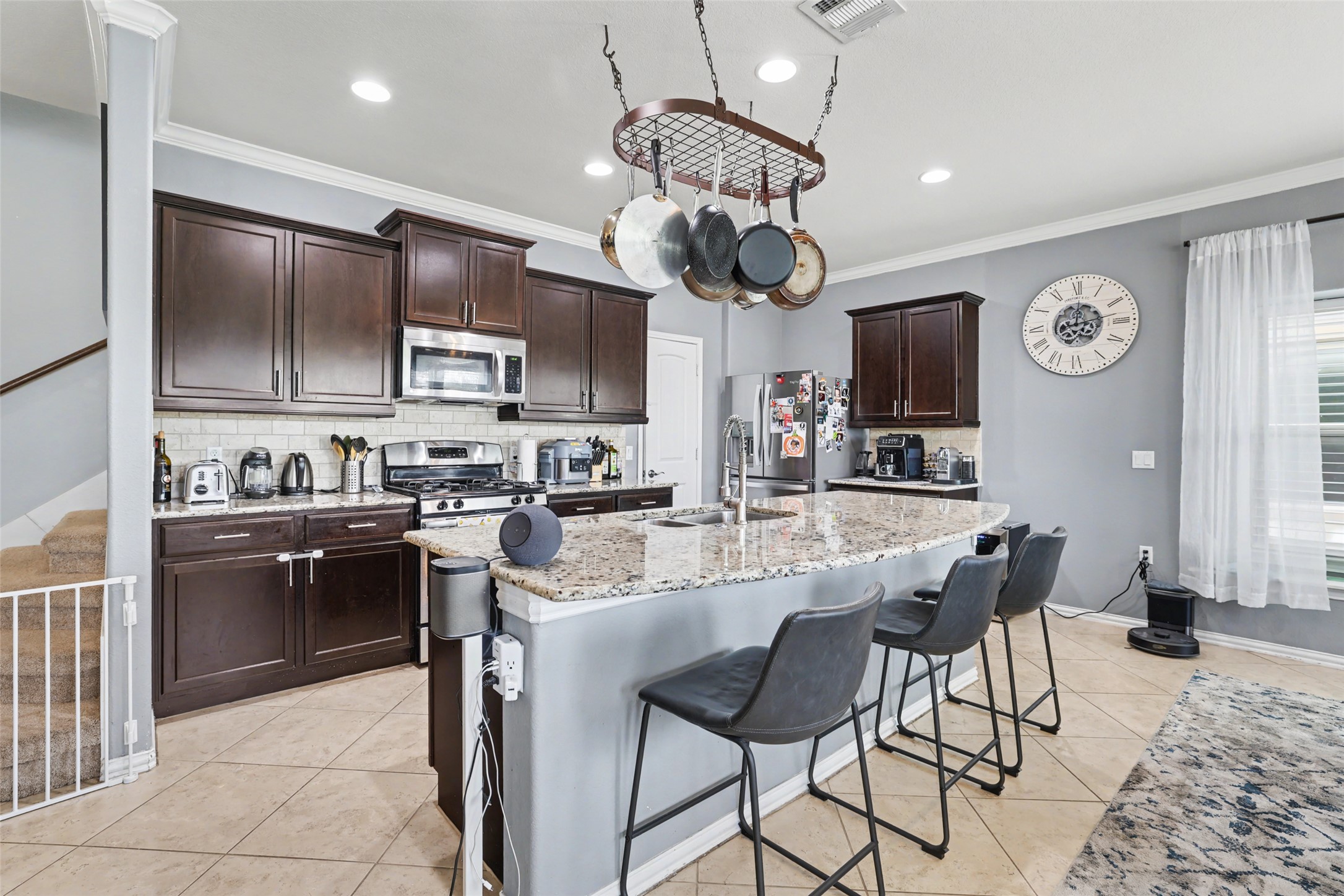 5845 Kleberg Trail Austin, TX 78747 - Photo 4 of 30 a kitchen with stainless steel appliances granite countertop a stove top oven a sink a dining table and chairs with wooden floor