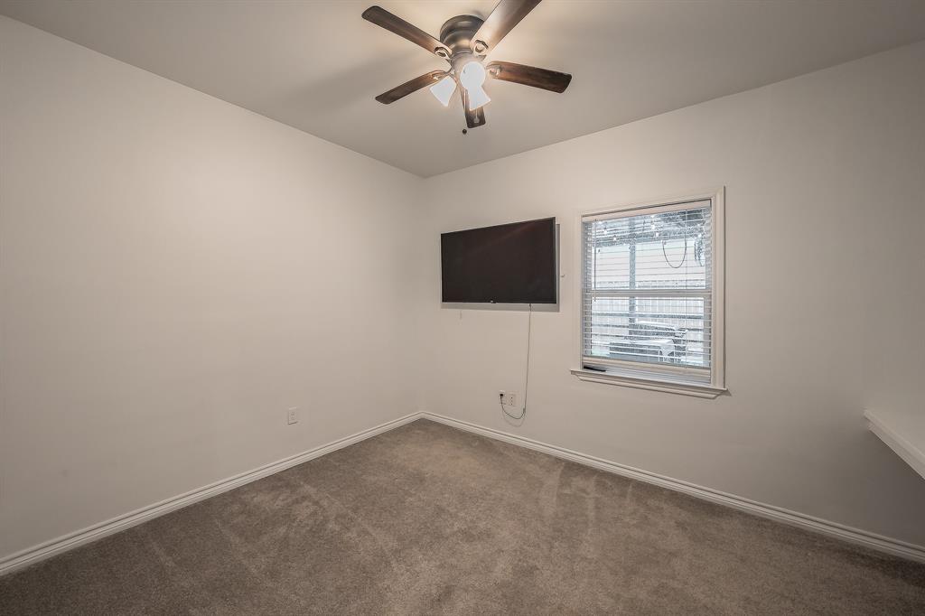 405 Dallas Street Rice, TX 75155 - Photo 7 of 40 an empty room with windows and a ceiling fan