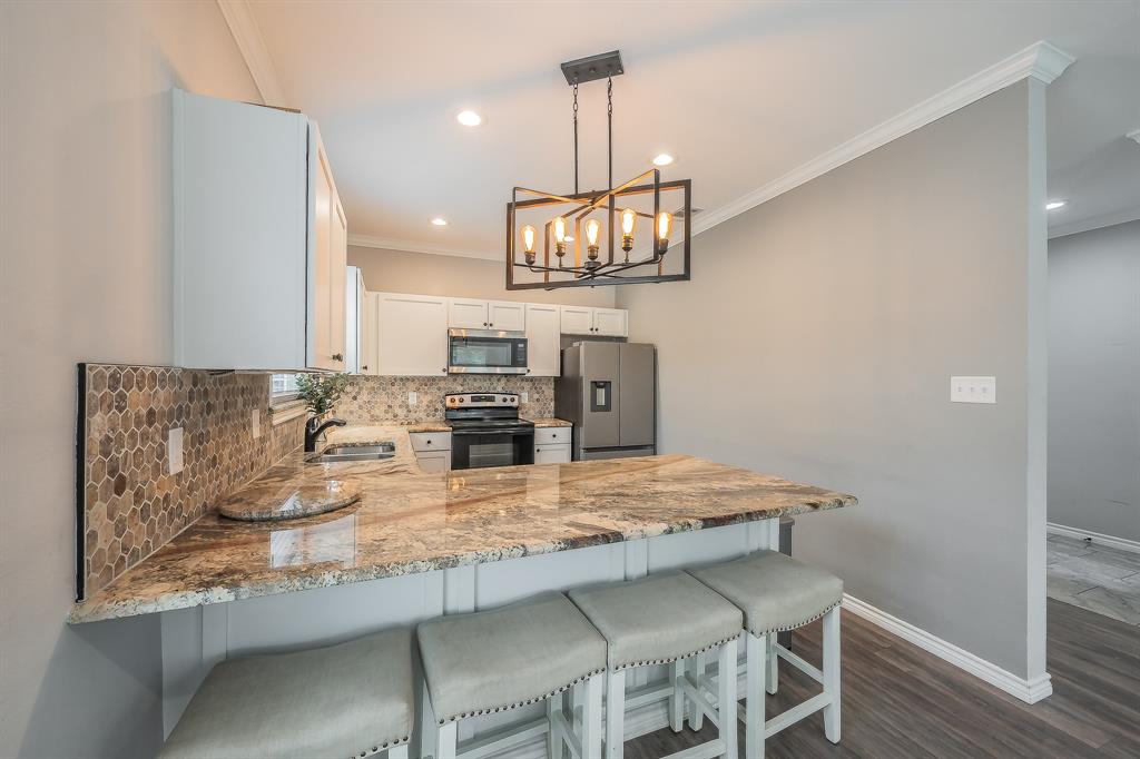 405 Dallas Street Rice, TX 75155 - Photo 10 of 40 a kitchen with granite countertop a table and chairs in it
