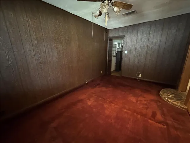 an empty room with chandelier fan