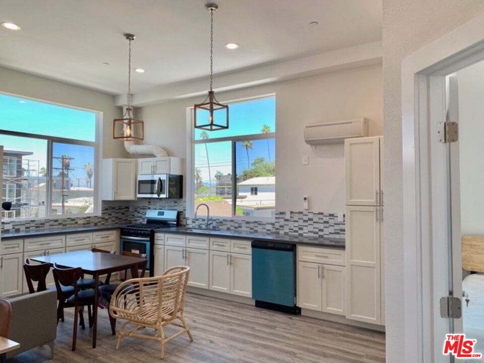 1129 West 37th Street, Unit 3 Los Angeles, CA 90007 - Photo 4 of 7 a kitchen with stainless steel appliances granite countertop wooden floors stove a sink and a refrigerator