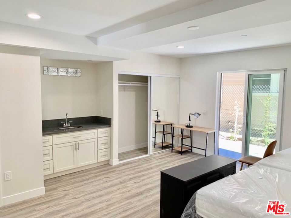 1129 West 37th Street, Unit 3 Los Angeles, CA 90007 - Photo 6 of 7 a bedroom with a bed and wooden floor
