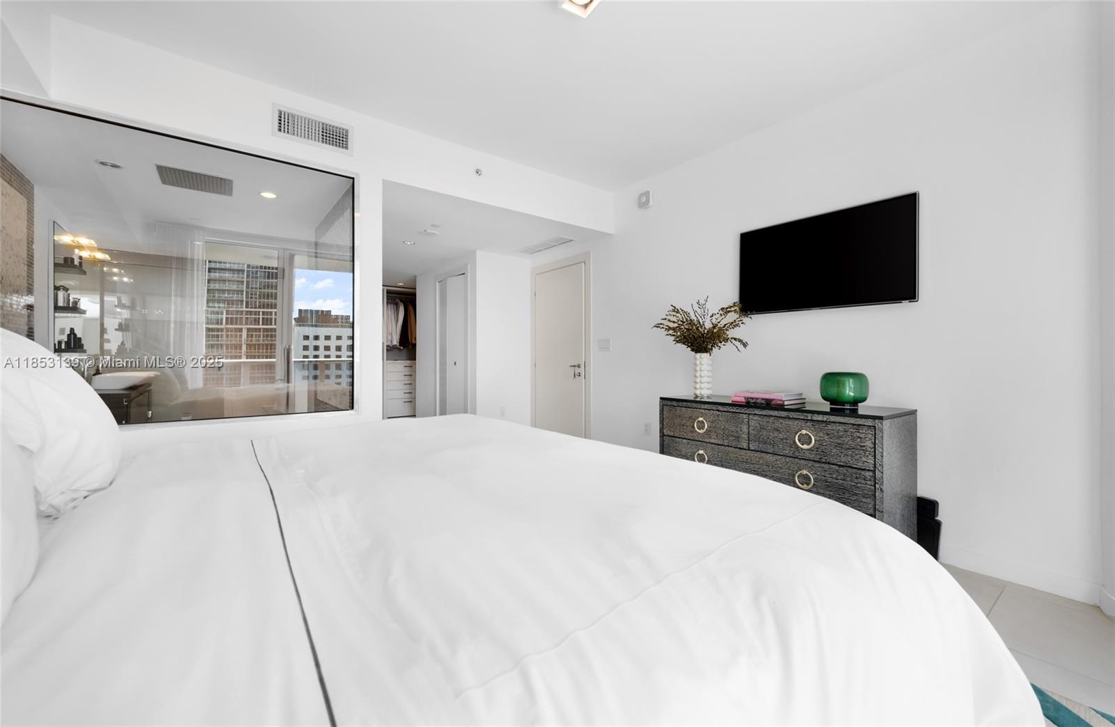 200 Biscayne Blvd Way, Unit 904 Miami, FL 33131 - Photo 14 of 24 a bedroom with a bed and a flat screen tv