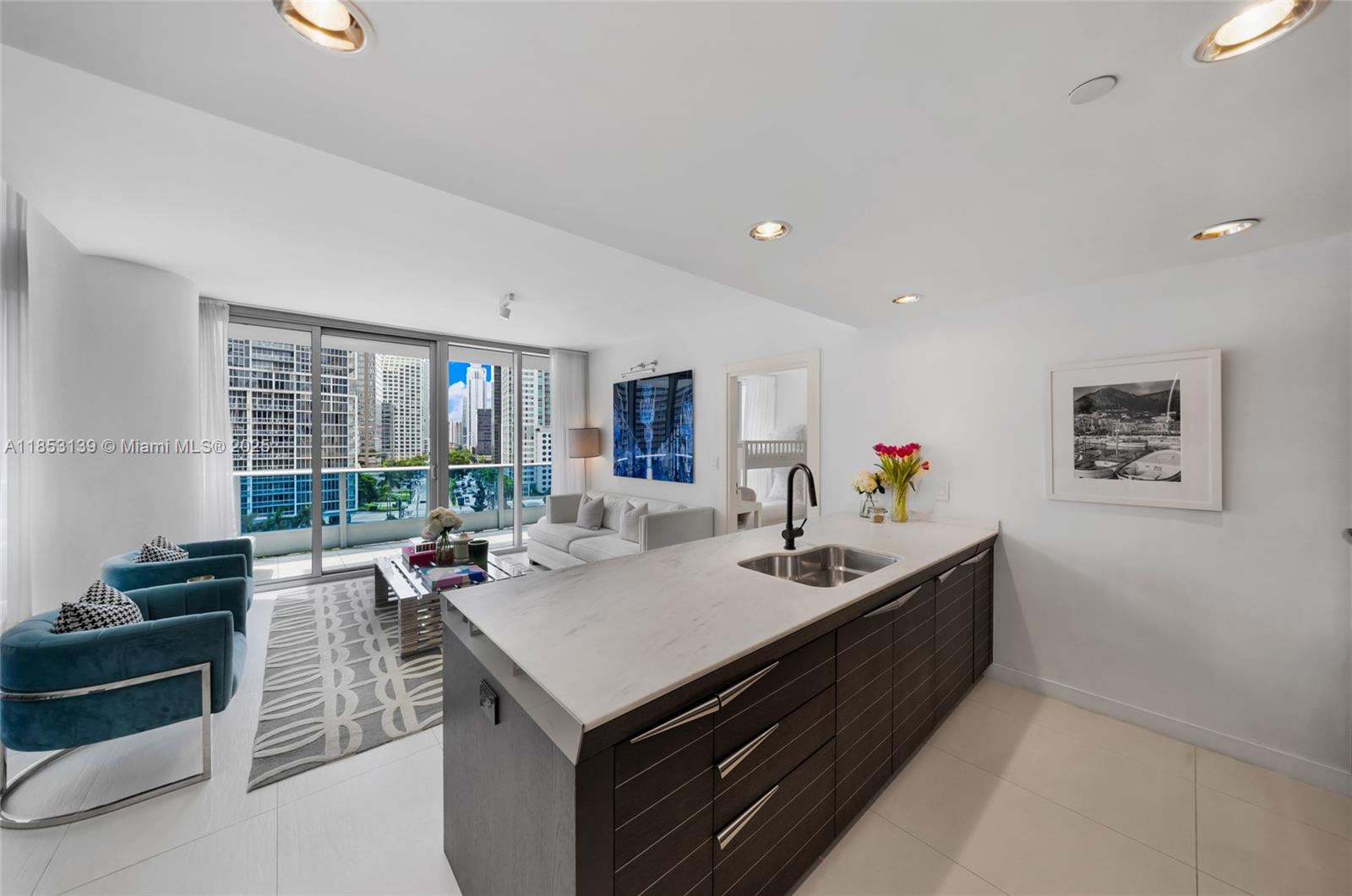 200 Biscayne Blvd Way, Unit 904 Miami, FL 33131 - Photo 10 of 24 a view of kitchen island with stainless steel appliances granite countertop a sink and a refrigerator