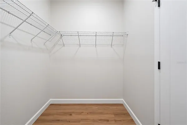 an empty room with a window and wooden floor
