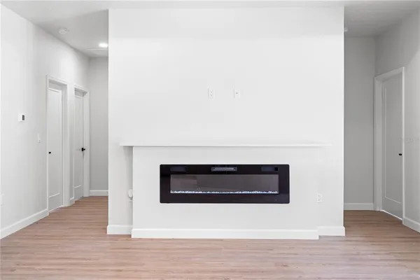an empty room with windows and a ceiling fan