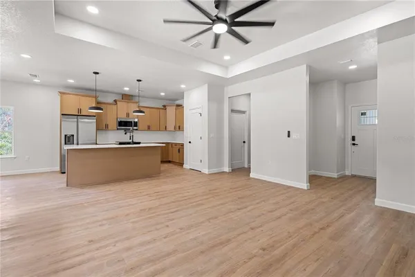 a view of a big room with wooden floor and windows