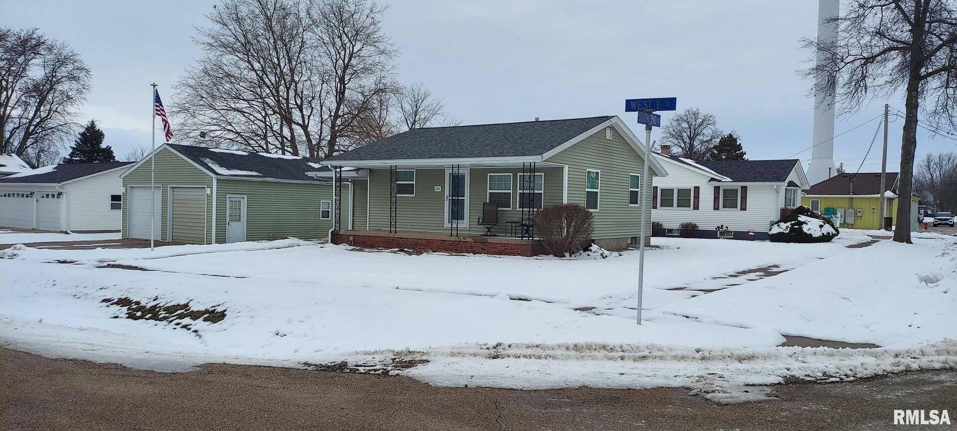 a front view of a house with a yard covered in snow