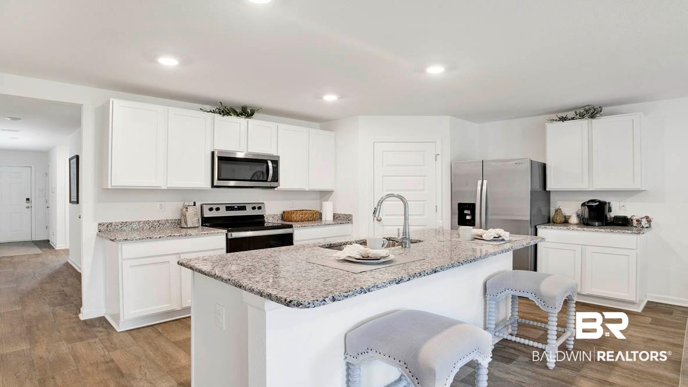 24718 Ponder Loop Loxley, AL 36551 - Photo 25 of 31 Kitchen featuring white cabinetry, light wood-type flooring, appliances with stainless steel finishes, and a center island with sink