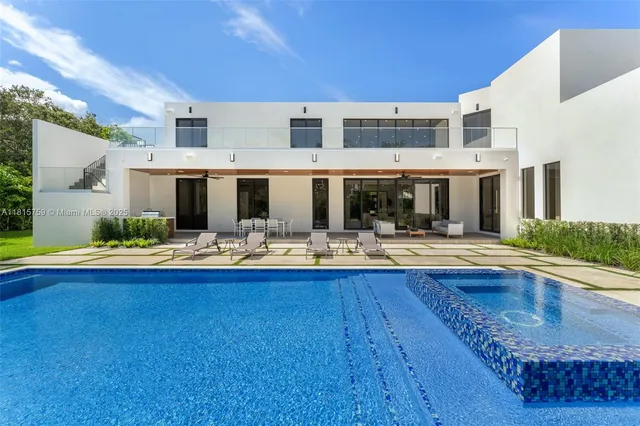 a view of a white house with a big yard and potted plants