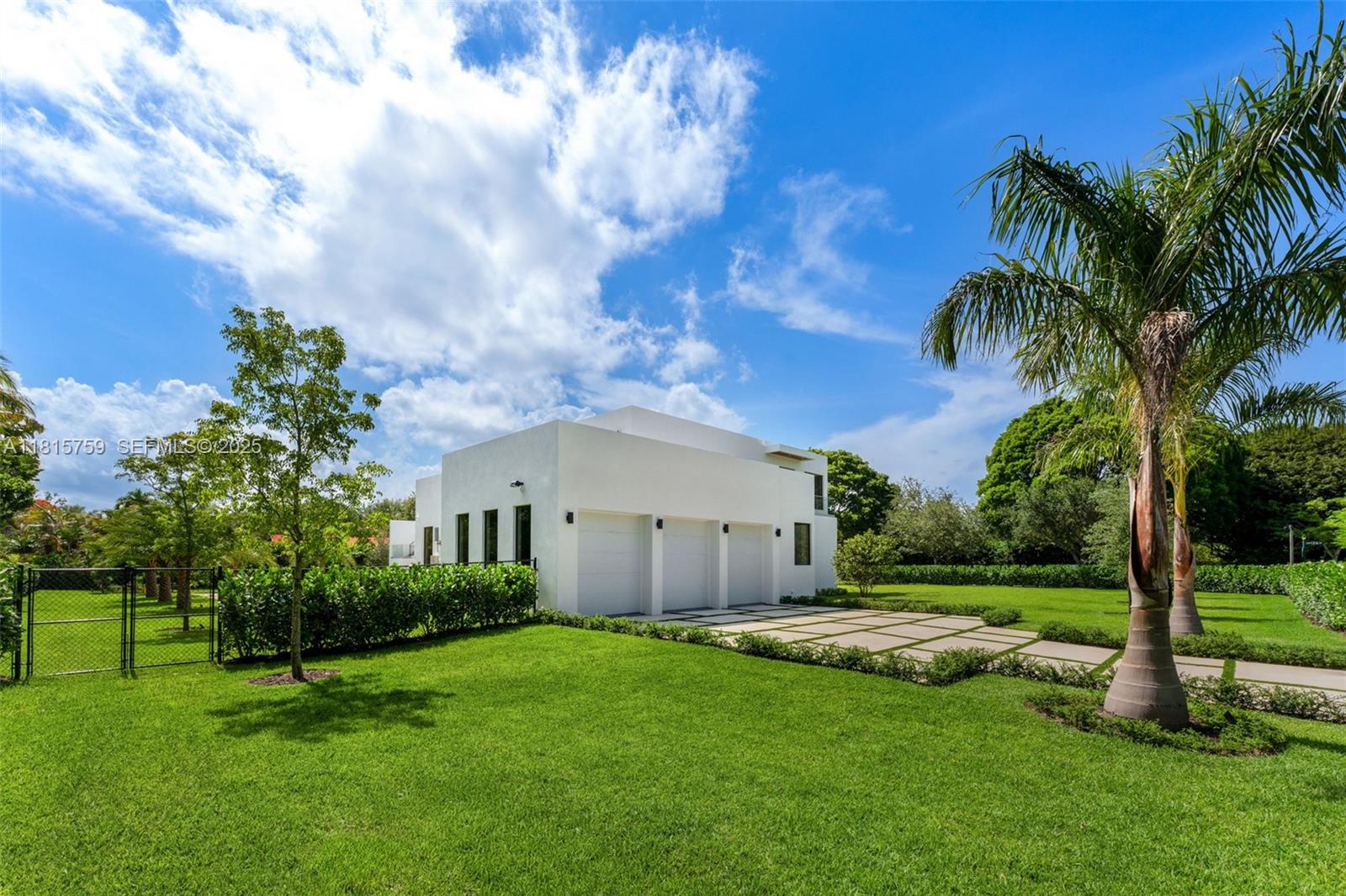 6200 Moss Ranch Road Pinecrest, FL 33156 - Photo 44 of 58 a view of a white house with a big yard and potted plants