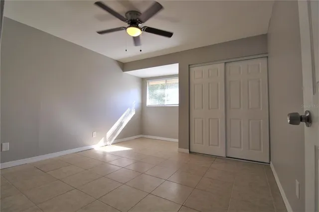 an empty room with fan and windows