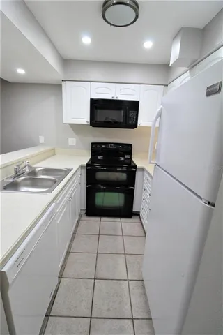 a kitchen with a sink a stove and a refrigerator