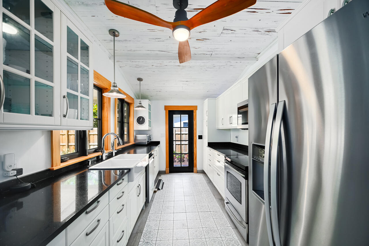 801 Hibiscus Street Boca Raton, FL 33486 - Photo 18 of 60 a large kitchen with stainless steel appliances granite countertop a refrigerator a stove and a sink with wooden floor