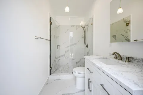 a bathroom with a shower a toilet and a sink