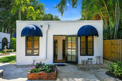 a view of a backyard with couches plants and large tree