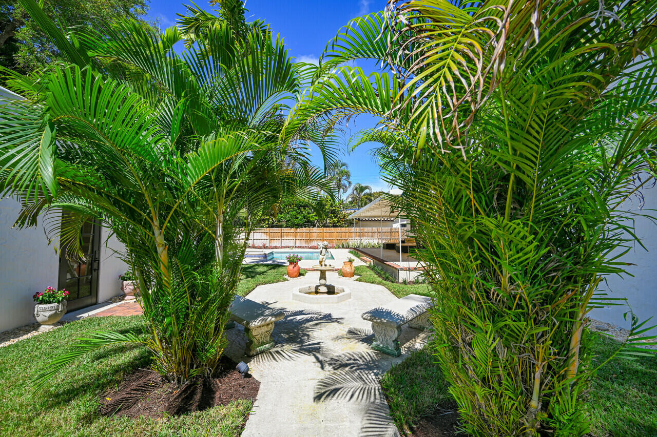801 Hibiscus Street Boca Raton, FL 33486 - Photo 52 of 60 a backyard of a house with table and chairs plants