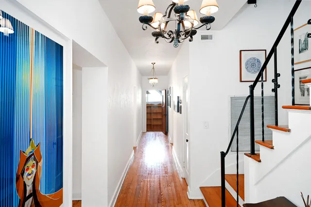 a view of a hallway with wooden floor and staircase