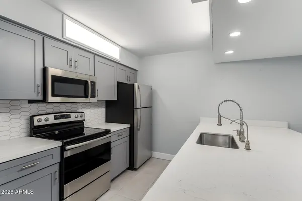 a kitchen with stainless steel appliances a stove microwave and sink