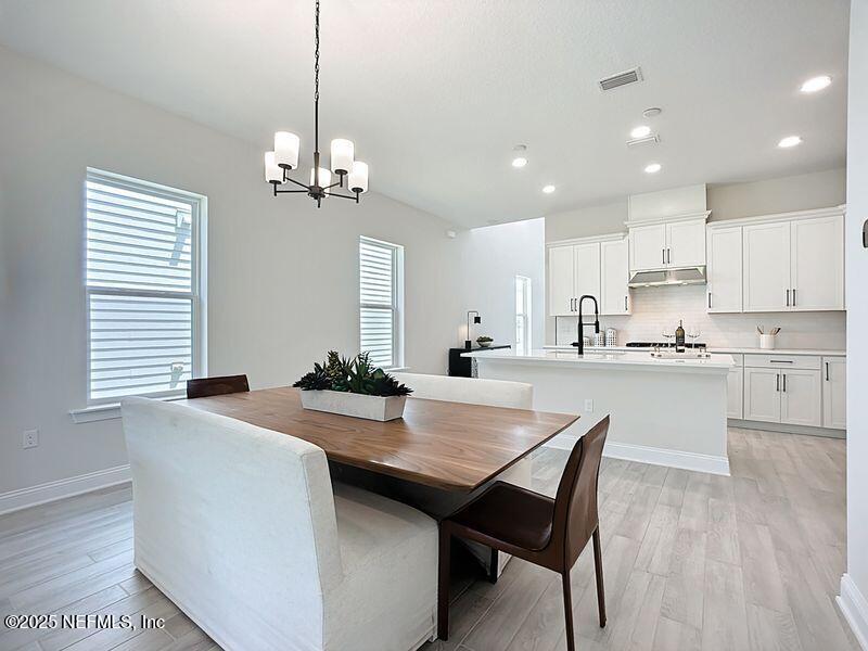 92 Bedford Terrace, Unit 60 St. Augustine, FL 32092 - Photo 13 of 42 a kitchen with granite countertop white cabinets a counter and chairs