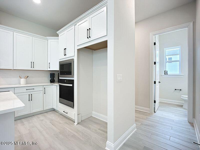 92 Bedford Terrace, Unit 60 St. Augustine, FL 32092 - Photo 14 of 42 a kitchen with cabinets appliances and wooden floor
