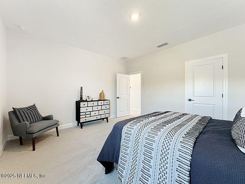 92 Bedford Terrace, Unit 60 St. Augustine, FL 32092 - Photo 23 of 42 a bedroom with a bed and a couch