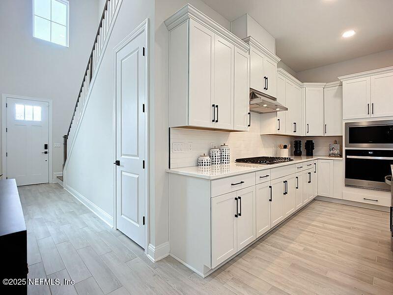 92 Bedford Terrace, Unit 60 St. Augustine, FL 32092 - Photo 8 of 42 a kitchen with granite countertop white cabinets and white appliances
