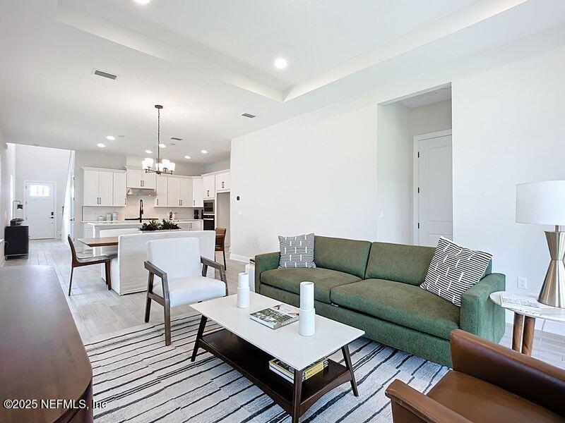 92 Bedford Terrace, Unit 60 St. Augustine, FL 32092 - Photo 10 of 42 a living room with furniture and a dining table with wooden floor