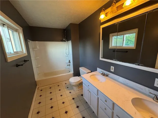 a bathroom with a sink a large mirror and a bathtub