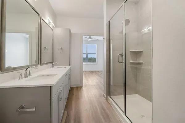 a bathroom with a granite countertop sink a shower and a mirror